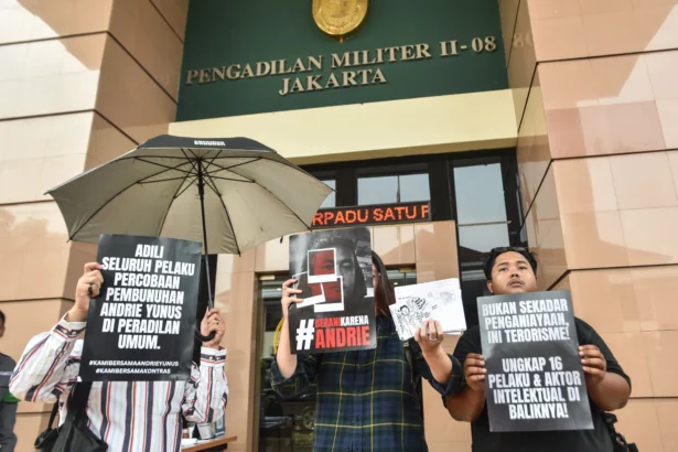 Aktivis KontraS membentangkan poster tuntutan usai Tim Advokasi untuk Demokrasi (TAUD) menyerahkan surat permintaan penghentian persidangan kasus dugaan penyiraman air keras terhadap aktivis KontraS Andrie Yunus di halaman Pengadilan Militer II-08 Jakarta, Senin (8/6/2026).
