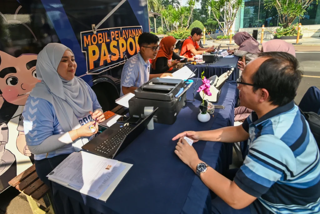 Petugas Imigrasi melayani warga yang mengurus paspor saat Hari Bebas Kendaraan Bermotor (HBKB) di kawasan Sudirman, Jakarta, Minggu (24/5/2026). (Sumber: Antara Foto/Fakhri Hermansyah/tom)