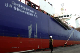 Seorang petugas satuan pengamanan melakukan patroli di sekitar kapal tanker berbendera asing yang akan memuat material crude palm oil (CPO) di Dermaga B Curah Cair Pelabuhan PT Pelindo Multi Terminal (SPMT) Branch Dumai, Riau, Rabu (13/5/2026).