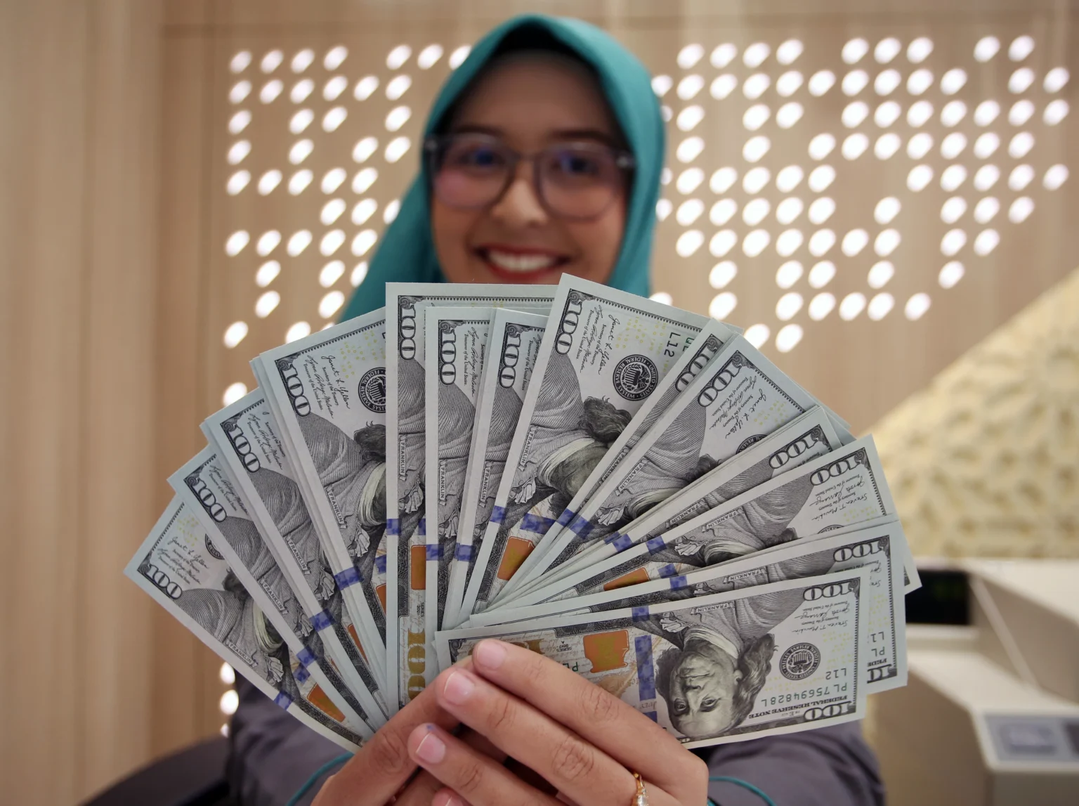 Karyawan memperlihatkan uang dolar Amerika Serikat (AS) di Kantor Cabang Bank Syariah Indonesia, Jakarta, Rabu (3/6/2026).