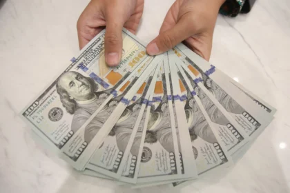 Karyawan memperlihatkan uang dolar Amerika Serikat (AS) di Kantor Cabang Bank Syariah Indonesia, Jakarta, Rabu (3/6/2026).
