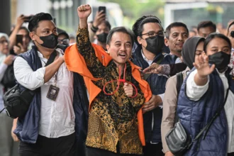 Petugas kepolisian menggiring Roy Suryo (tengah) ke dalam gedung di Kejaksaan Negeri Jakarta Selatan, Jakarta, Senin (22/6/2026).