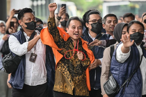 Petugas kepolisian menggiring Roy Suryo (tengah) ke dalam gedung di Kejaksaan Negeri Jakarta Selatan, Jakarta, Senin (22/6/2026).