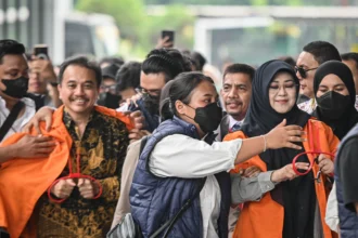 Petugas kepolisian menggiring Roy Suryo (kiri) dan Tifauzia Tyassuma (kanan) ke dalam gedung di Kejaksaan Negeri Jakarta Selatan, Jakarta, Senin (22/6/2026).