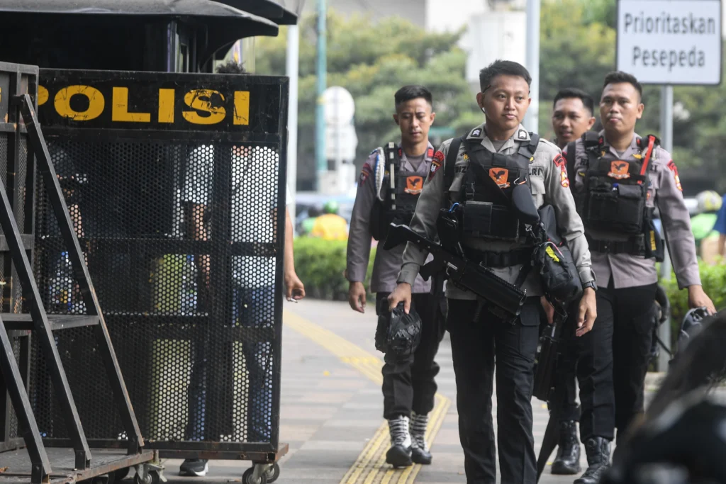 Anggota kepolisian dari korps Brimob berjalan saat melakukan pengamanan di kawasan Bundaran HI, Jakarta, Senin (15/6/2026).