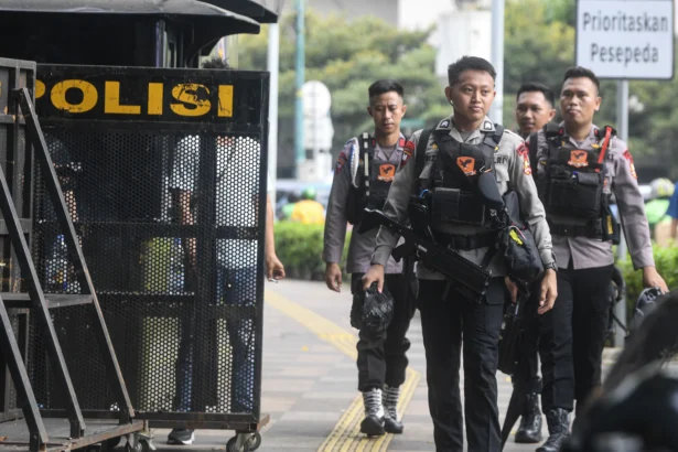Anggota kepolisian dari korps Brimob berjalan saat melakukan pengamanan di kawasan Bundaran HI, Jakarta, Senin (15/6/2026).