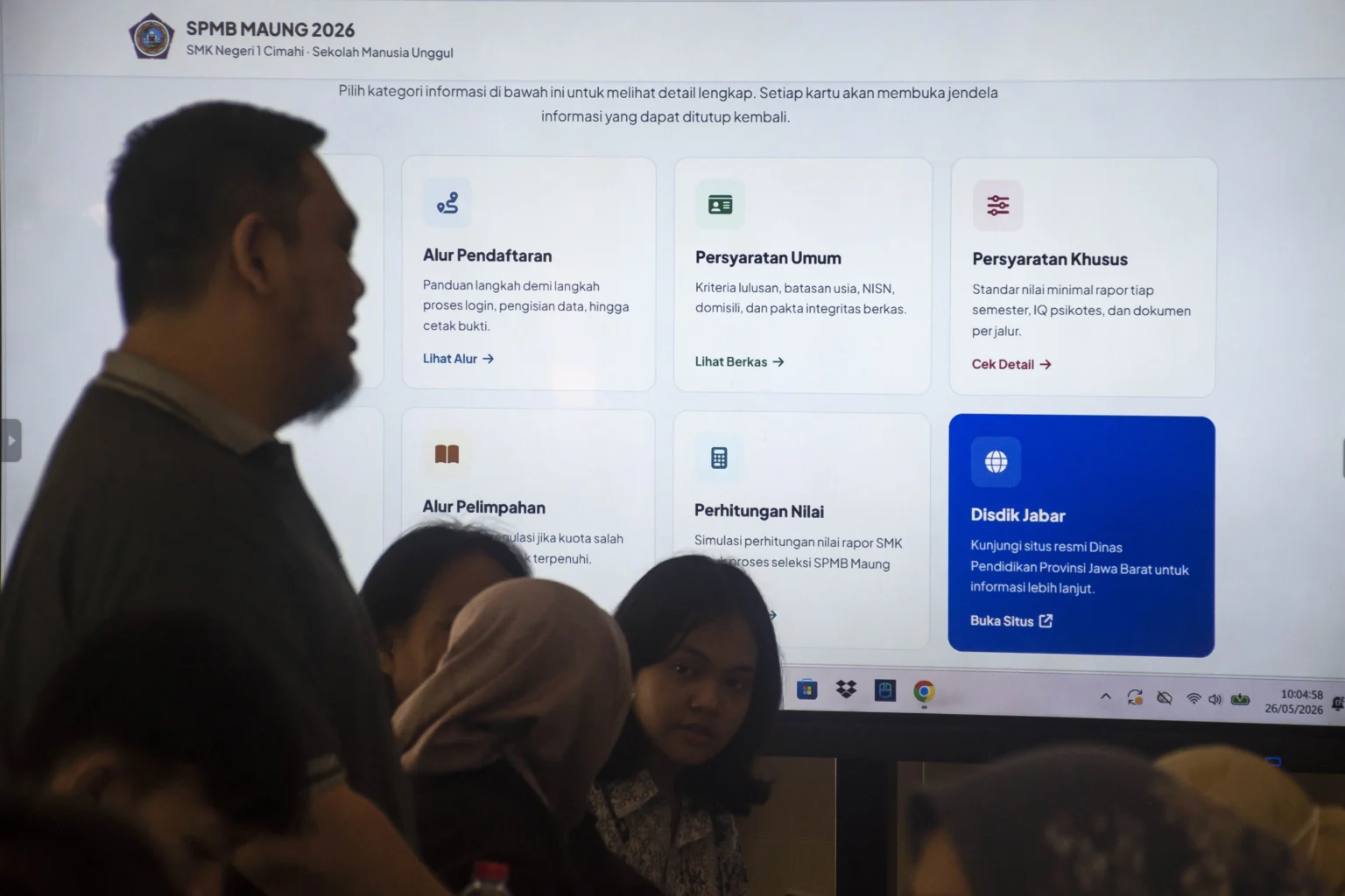 Orang tua siswa berdiri di depan layar informasi Sistem Penerimaan Murid Baru (SPMB) Sekolah Manusia Unggul (Maung) di SMKN 1 Cimahi, Jawa Barat, Selasa (26/5/2026).