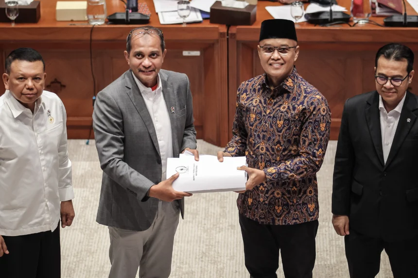 Wakil Ketua Komisi I DPR Sukamta (kedua kanan) menyerahkan Daftar Inventarisasi Masalah (DIM) kepada Wakil Menteri Hukum Edward Omar Sharif Hiariej (kedua kiri) didampingi Wakil Menteri Sekretaris Negara Bambang Eko Suhariyanto (kiri) dan Wakil Menteri Komunikasi dan Digital Nezar Patria (kanan) saat rapat kerja di Kompleks Parlemen, Senayan, Jakarta, Senin (29/6/2026).