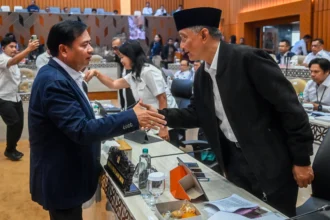 Menteri Pekerjaan Umum (PU) Dody Hanggodo (kanan) berjabat tangan dengan Ketua Komisi V DPR Lasarus (kiri) sebelum mengikuti rapat kerja dengan Komisi V DPR di Kompleks Parlemen, Senayan, Jakarta, Selasa (2/6/2026).