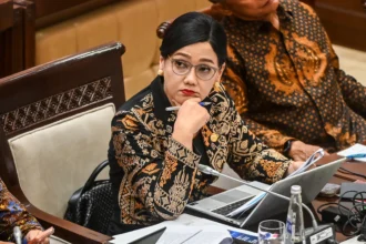 Ketua Dewan Komisioner OJK Friderica Widyasari mendengarkan pandangan fraksi saat mengikuti rapat kerja dengan Komisi XI DPR di Kompleks Parlemen, Senayan, Jakarta, Kamis (21/5/2026).