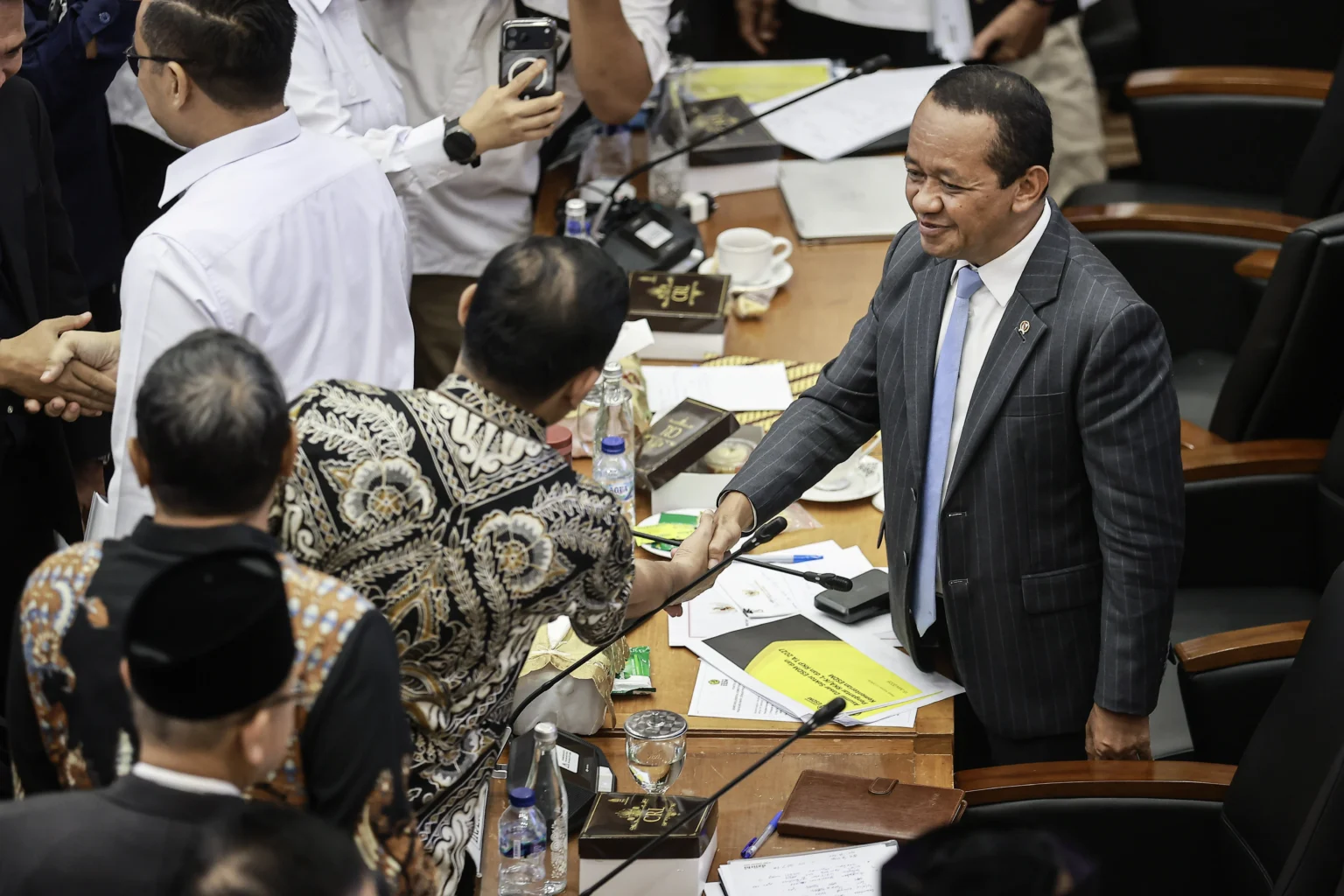 Menteri ESDM Bahlil Lahadalia (kanan) berjabat tangan dengan anggota Komisi XII DPR usai rapat kerja di Kompleks Parlemen, Senayan, Jakarta, Senin (15/6/2026).