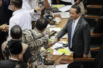 Menteri ESDM Bahlil Lahadalia (kanan) berjabat tangan dengan anggota Komisi XII DPR usai rapat kerja di Kompleks Parlemen, Senayan, Jakarta, Senin (15/6/2026).