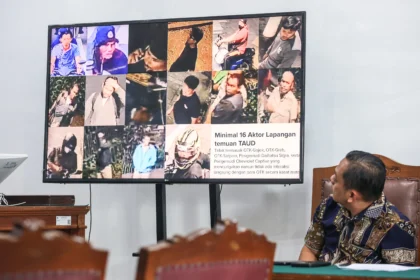 Tim Bidang hukum Polda Metro Jaya melihat layar yang menampilkan bukti dalam sidang lanjutan praperadilan kasus penyiraman air keras kepada aktivis KontraS Andrie Yunus di Pengadilan Negeri Jakarta Selatan, Jakarta, Jumat (22/5/2026).