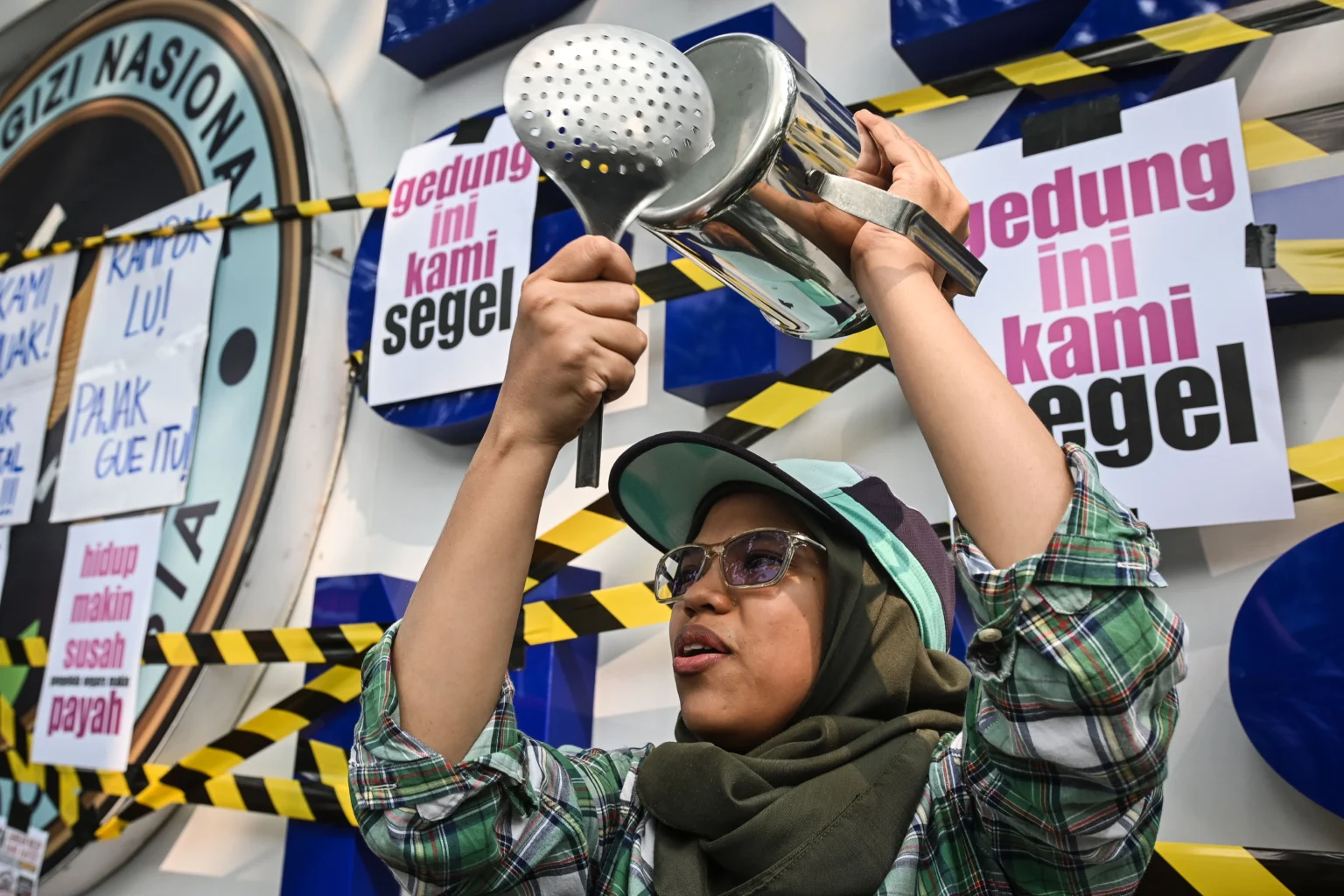 Warga yang tergabung dalam aliansi MBG Watch membawa peralatan dapur saat aksi unjuk rasa di depan kantor Badan Gizi Nasional (BGN), Jakarta Pusat