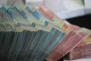 Tumpukan uang rupiah dari tabungan masyarakat. (Sumber: Unsplash/Mufid Majnun)