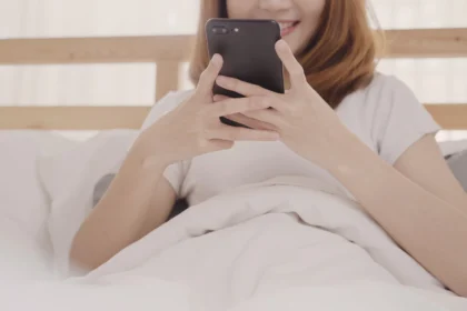 Ilustrasi main handphone di tempat tidur