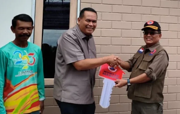 Sekretaris Utama BNPB Rustian menyerahkan kunci rumah hunian tetap mandiri kepada warga terdampak bencana Siklon Senyar wilayah Sumatra Barat, 10 Juli 2026.