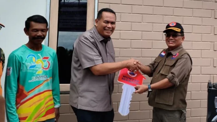 Sekretaris Utama BNPB Rustian menyerahkan kunci rumah hunian tetap mandiri kepada warga terdampak bencana Siklon Senyar wilayah Sumatra Barat, 10 Juli 2026.