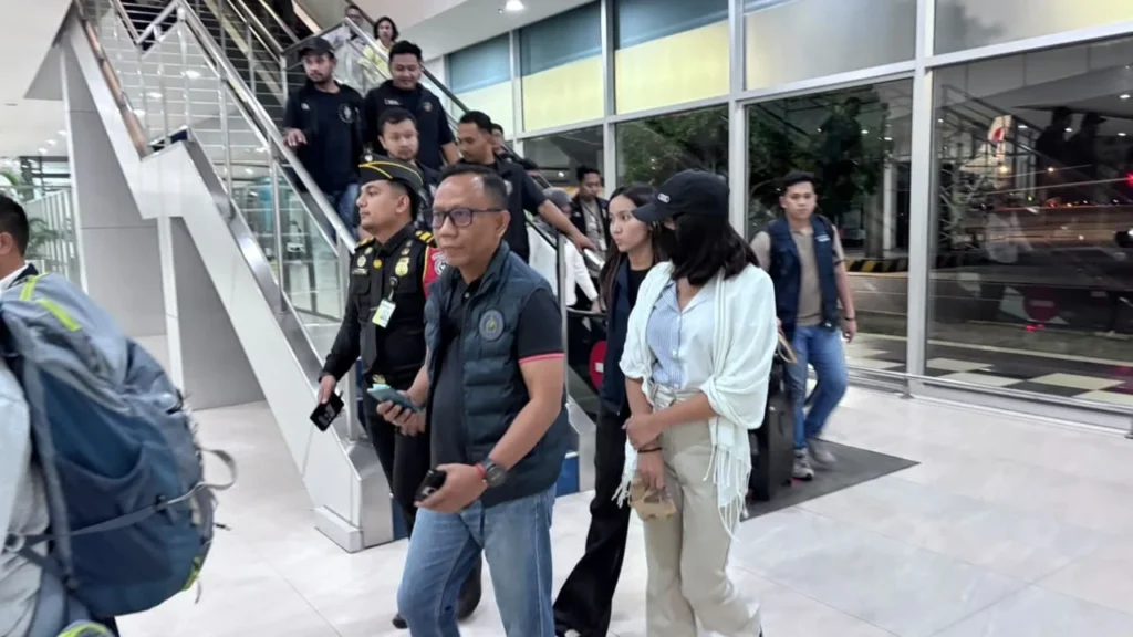 Buron kasus TPPO Leny Agustya, memakai topi dan masker, diamankan penyidik Polri dan petugas Imigrasi.