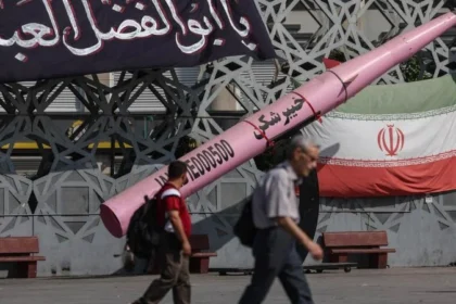 Warga Iran melintasi pemeran tekonologi militer rudal milik IRGC.
