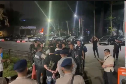 Tangkapan layar yang menampilkan belasan pria berseragam dinas dan membawa senjata laras panjang di kawasan Polda Metro Jaya