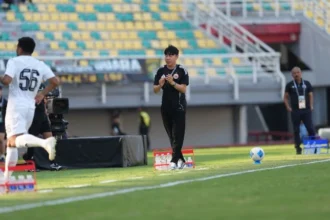 Pelatih Persija Shin Tae-yong memberi instruksi di pinggir lapangan.