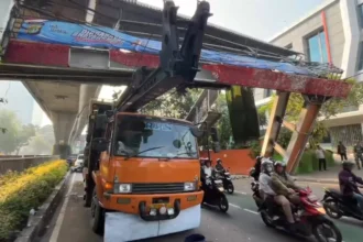 Sebuah truk pengangkut alat berat tersangkut Jembatan Penyebrangan Orang di jalan Kapten Tendean, Mampang Prapatan, Jakarta Selatan, Selasa, 14 Juli 2026.