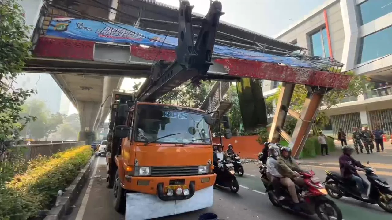 Sebuah truk pengangkut alat berat tersangkut Jembatan Penyebrangan Orang di jalan Kapten Tendean, Mampang Prapatan, Jakarta Selatan, Selasa, 14 Juli 2026.