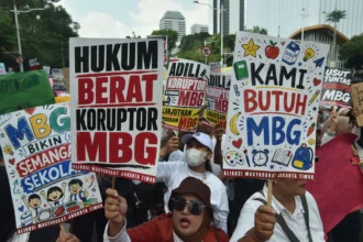 Massa dari Aliansi Masyarakat Jakarta Timur memegang poster saat berunjuk rasa di Jakarta, Rabu (17/6/2026).