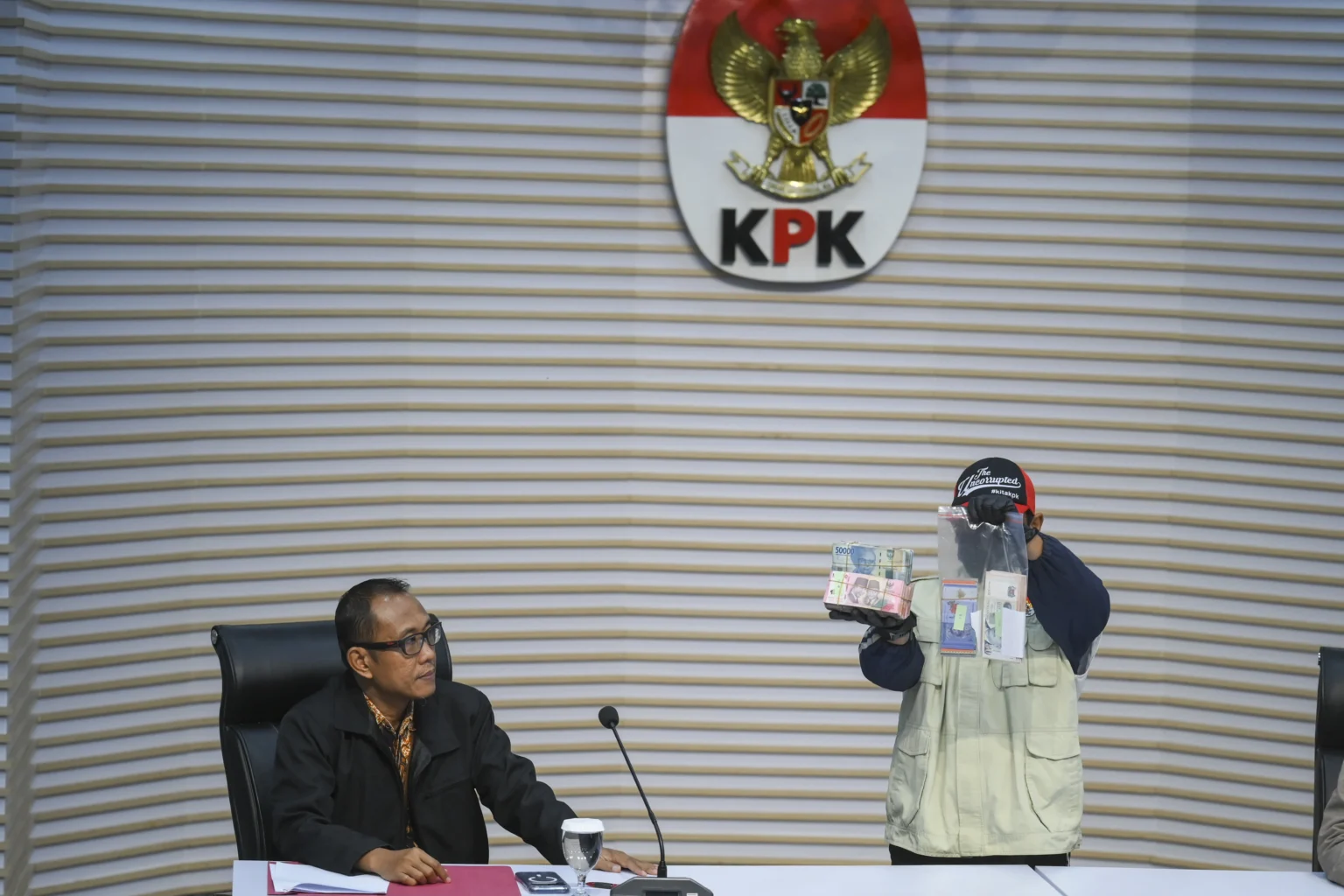 Plt. Direktur Penyidikan KPK Achmad Taufik Husein (kiri) menyaksikan petugas KPK menunjukkan barang bukti uang tunai saat konferensi pers operasi tangkap tangan Bupati Langkat Syah Afandin di Gedung Merah Putih KPK, Jakarta, Jumat (3/7/2026). (Sumber: Antara Foto/Hafidz Mubarak A/sgd)