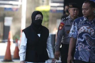 Bupati Sukoharjo Etik Suryani (kiri) dikawal petugas saat tiba untuk menjalani pemeriksaan di Gedung Merah Putih KPK, Jakarta, Jumat (10/7/2026).