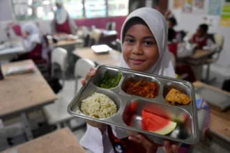 Siswa menunjukan menu Makan Bergizi Gratis (MBG) di SDN 002 Balikpapan Tengah, Kalimantan Timur, Senin (20/7/2026).