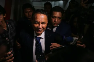 Pengacara Hotman Paris Hutapea (tengah) berjalan memasuki Gedung Bundar saat tiba di Kejaksaan Agung, Jakarta, Jumat (17/7/2026).