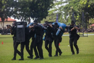 Sejumlah anggota Polri memperagakan simulasi penangkapan taktis dan pengamanan saat upacara peringatan HUT Ke-80 Bhayangkara di Lapangan Polda Kepri, Batam, Kepulauan Riau, Rabu (1/7/2026).