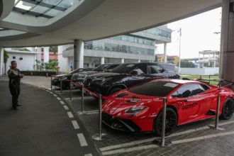 Pekerja mengamati mobil sitaan penyidik Jaksa Agung Muda Bidang Tindak Pidana Khusus (Jampidsus) di Kejaksaan Agung, Jakarta, Jumat (3/7/2026).