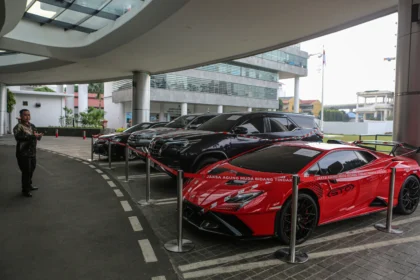 Pekerja mengamati mobil sitaan penyidik Jaksa Agung Muda Bidang Tindak Pidana Khusus (Jampidsus) di Kejaksaan Agung, Jakarta, Jumat (3/7/2026).