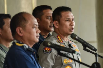 Kabid Humas Polda Metro Jaya Kombes Pol Bhudi Hermanto (kanan) bersama Kapuspenkum Kejagung Anang Supriatna (kiri) memberikan keterangan pada konferensi pers di Gedung Jampidsus Kejaksaan Agung, Jakarta, Jumat (17/7/2026).