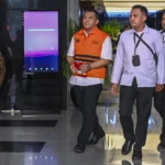 Tersangka kasus dugaan korupsi pengurusan izin tinggal warga negara asing (WNA) di Indonesia Silmy Karim (kiri) berjalan usai diperiksa di Gedung Merah Putih KPK, Jakarta, Senin (8/6/2026).