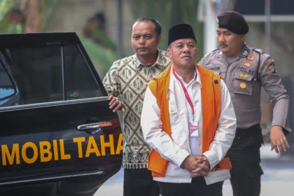 Tersangka kasus dugaan suap jual beli jabatan sekretaris daerah, Suhardiman Amby (tengah) berjalan menuju mobil tahanan usai menjalani pemeriksaan di Gedung Merah Putih KPK, Jakarta, Jumat (17/7/2026).