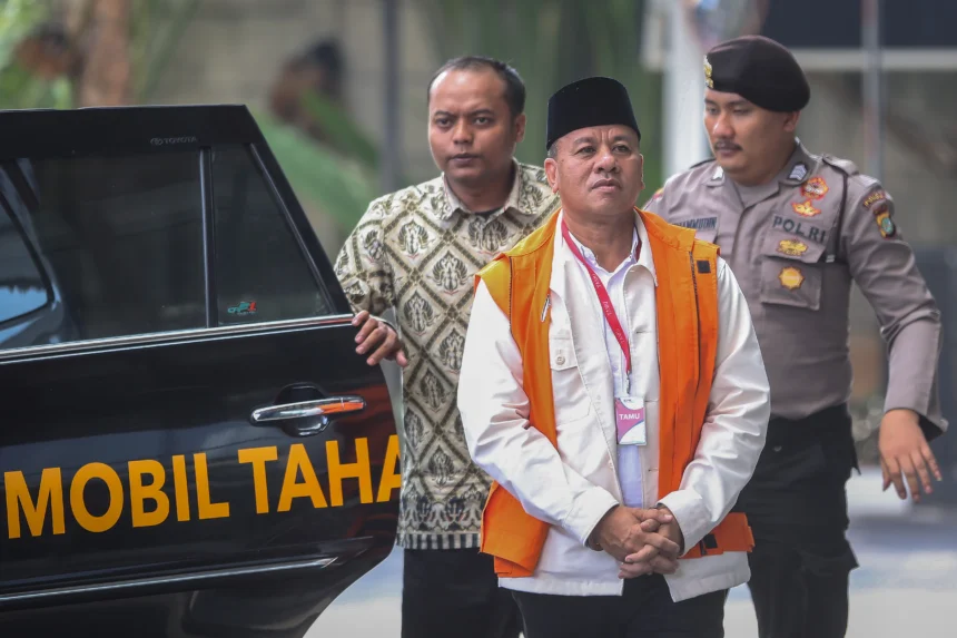 Tersangka kasus dugaan suap jual beli jabatan sekretaris daerah, Suhardiman Amby (tengah) berjalan menuju mobil tahanan usai menjalani pemeriksaan di Gedung Merah Putih KPK, Jakarta, Jumat (17/7/2026).