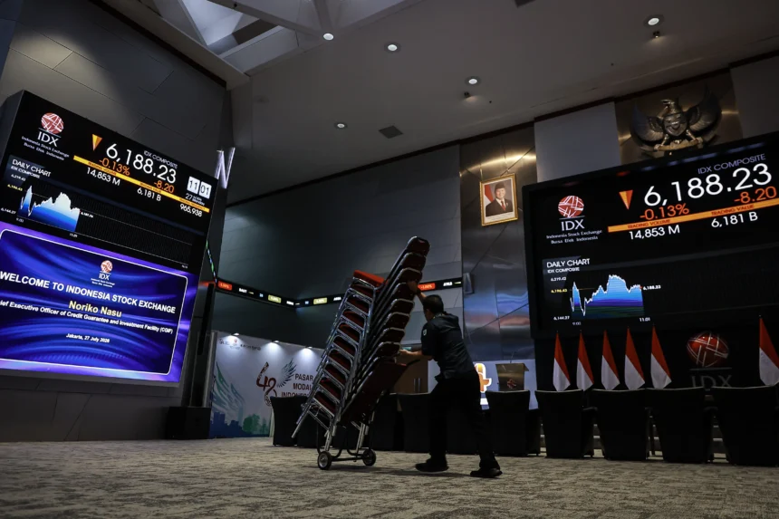 Pekerja melintas di dekat layar pergerakan Indeks Harga Saham Gabungan (IHSG) di Bursa Efek Indonesia (BEI), Jakarta, Senin (27/7/2026). (Sumber: Antara Foto/Dhemas Reviyanto/wsj)