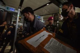 Personel Direktorat Reserse Kriminal Khusus Polda Metro Jaya membawa barang bukti kasus dugaan korupsi Tindak Pidana Pencucian uang (TPPU) saat tiba di Gedung Jampidsus Kejaksaan Agung, Jakarta, Jumat (17/7/2026).