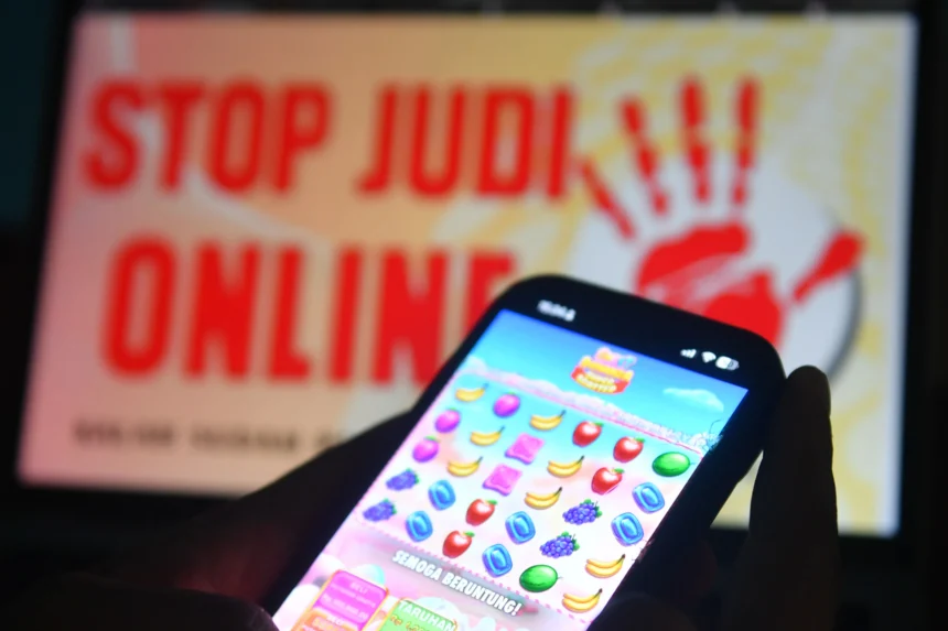 Warga melihat situs judi online melalui gawainya di Balikpapan, Kalimantan Timur, Jumat (24/7/2026).