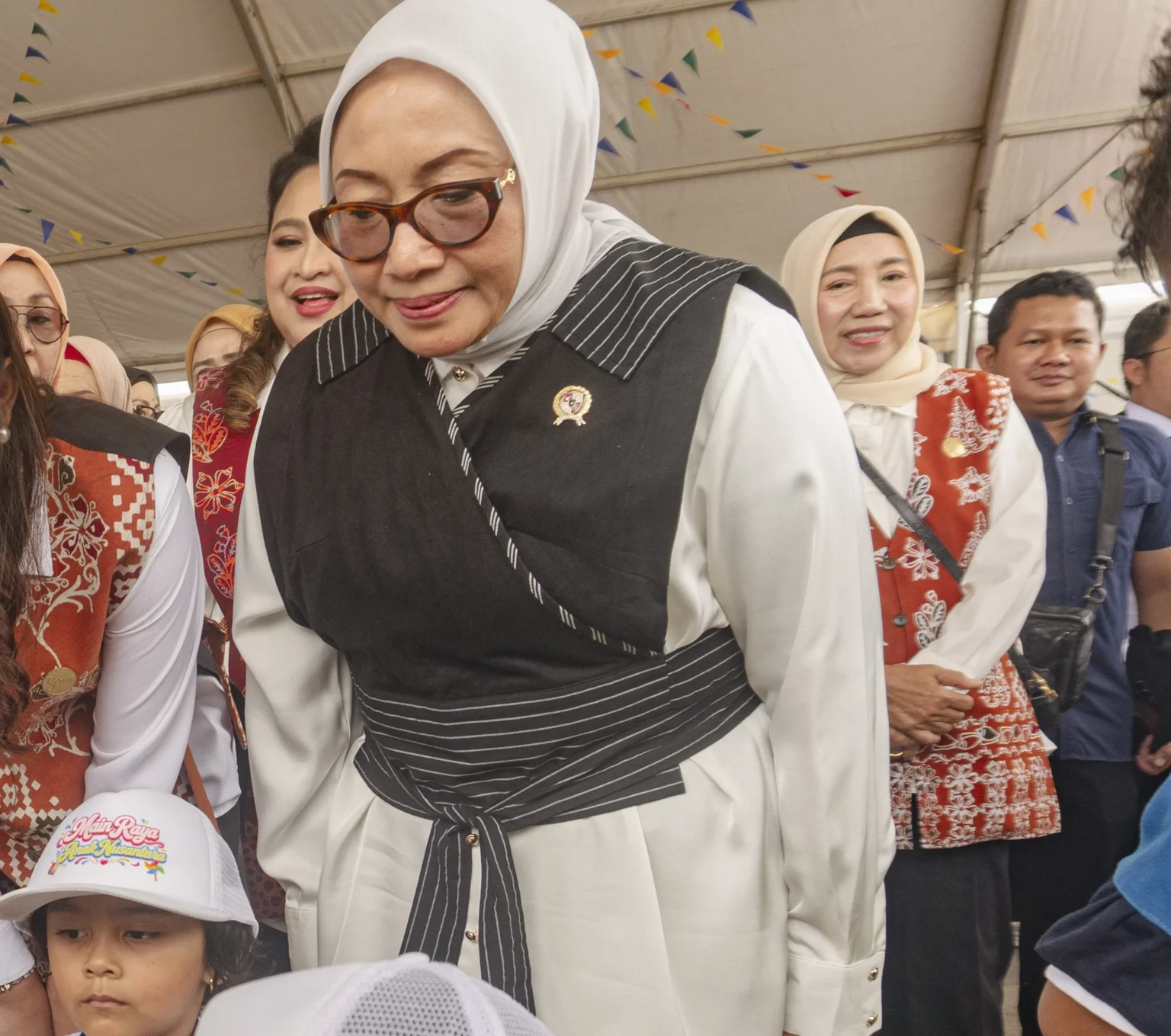 Menteri PPPA Arifah Fauzi (kanan) melihat anak-anak bermain saat meninjau stan edukasi pada puncak peringatan Hari Anak Nasional (HAN) 2026 di kawasan Tugu Sirih, Tanjungpinang, Kepulauan Riau, Kamis (23/7/2026). Peringatan HAN 2026 yang mengusung gerakan "Main Raya Anak Nusantara" tersebut berfokus pada pemenuhan hak bermain, ruang aman, serta perlindungan menyeluruh bagi anak-anak di seluruh Indonesia. (ANTARA FOTO/Teguh Prihatna)