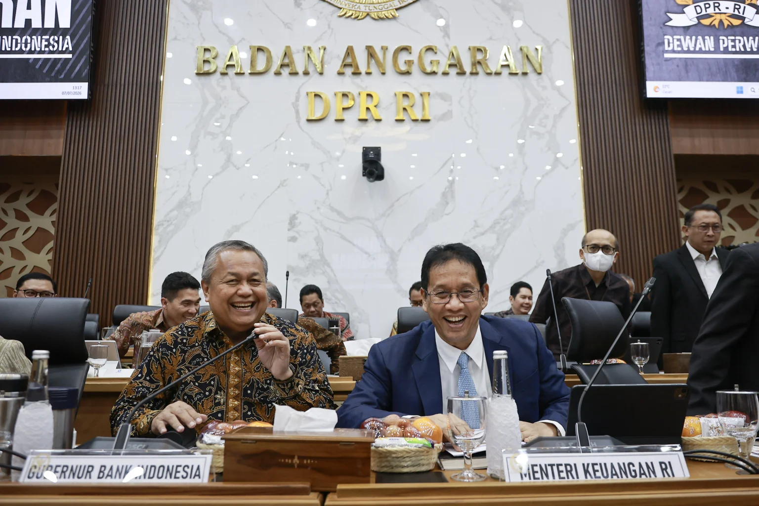 Menteri Keuangan Purbaya Yudhi Sadewa (kanan) bersama Gubernur Bank Indonesia Perry Warjiyo (kiri) bersiap mengikuti rapat kerja dengan Badan Anggaran (Banggar) DPR di Kompleks Parlemen, Senayan, Jakarta, Selasa (7/7/2026).
