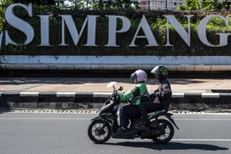 Pengendara ojek daring mengangkut penumpang di kawasan Simpang Lima, Semarang, Jawa Tengah, Senin (29/6/2026).