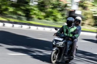 Pengendara ojek daring mengangkut penumpang di kawasan Simpang Lima, Semarang, Jawa Tengah, Senin (29/6/2026).