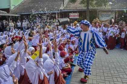 Anggota Komunitas Badut Cimahi bermain gelembung sabun bersama murid baru saat kegiatan Masa Pengenalan Lingkungan Sekolah (MPLS) di kompleks SDN Cibeber, Kota Cimahi, Jawa Barat