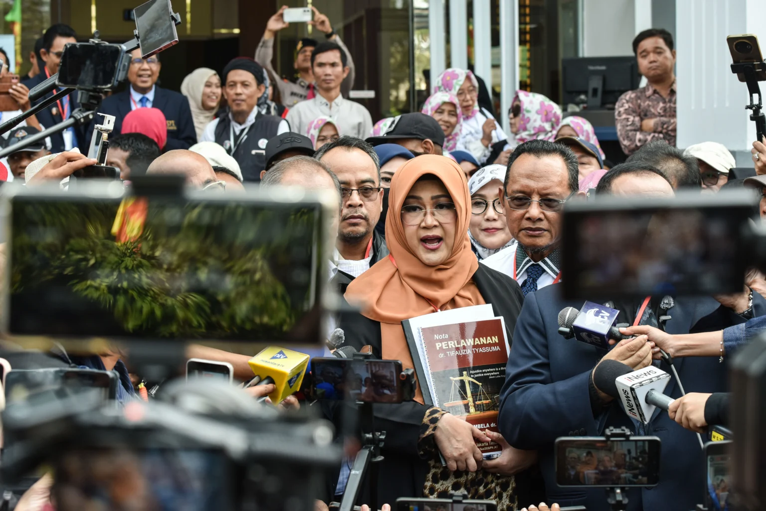 Terdakwa kasus dugaan fitnah dan pencemaran nama baik terkait keaslian ijazah Presiden ke-7 RI Joko Widodo, Tifauzia Tyassuma atau Dokter Tifa (tengah), memberikan keterangan kepada wartawan usai menjalani sidang lanjutan di Pengadilan Negeri Jakarta Timur, Jakarta, Kamis (9/7/2026).