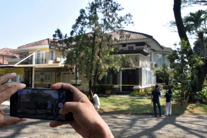 Jurnalis televisi merekam suasana rumah mewah yang dipasangi garis polisi usai penggeledahan di kawasan Sentul, Babakan Madang, Kabupaten Bogor, Jawa Barat, Kamis (9/7/2026).